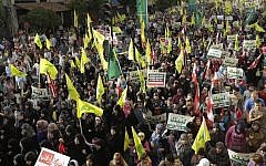 Hezbollah supporters wave flags and hold up Arabic banners that read, "At your service God's prophet; America equals terrorism; and America does not equal freedom," during an anti-US rally in Beirut, Lebanon, in September, 2012 (photo credit: AP/Hussein Malla)
