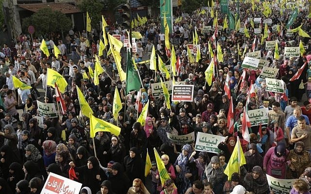 Hezbollah supporters wave flags and hold up Arabic banners that read, "At your service God's prophet; America equals terrorism; and America does not equal freedom," during an anti-US rally in Beirut, Lebanon, in September, 2012 (photo credit: AP/Hussein Malla) Hezbollah supporters wave flags and hold up Arabic banners that read, "At your service God's prophet; America equals terrorism; and America does not equal freedom," during an anti-US rally in Beirut, Lebanon, in September, 2012 (photo credit: AP/Hussein Malla)