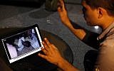 Fahd al-Bakoush, a freelance videographer, 22, shows a video he took of the body of U.S. Ambassador Chris Stevens being carried out of a small dark room in the U.S. consulate in Benghazi. (photo credit: AP/Mohammad Hannon)