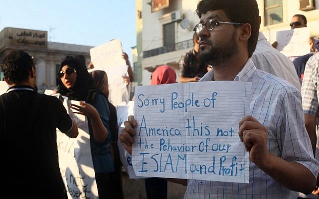A Libyan man holds a placard in English during a demonstration on Wednesday, Sept. 12, 2012, against the attack on the US Consulate that killed four Americans, including the ambassador, in Benghazi, Libya. (photo credit: Ibrahim Alaguri/AP)