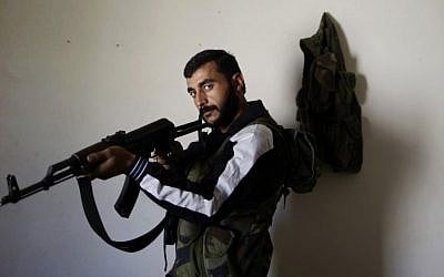 In this Wednesday, Sept. 5, 2012, photo, Syrian rebel fighter, Hamzah Alhassan, 25, a former blacksmith, poses for a picture at a house where he and others wait their turn to go and fight against government forces in Aleppo. (AP Photo/Muhammed Muheisen)