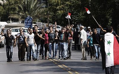 Pro-Assad supporters chant slogans during a demonstration in Damascus, Syria, on Friday, as part of widespread anger across the Muslim world about a film ridiculing Islam's Prophet Muhammad (photo credit: AP/Muzaffar Salman)