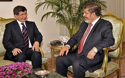Egyptian President Mohammed Morsi, right, meets with Turkish Foreign Minister Ahmet Davutoglu at the Presidential Palace in Cairo, Egypt on Monday. (photo credit: AP/Egyptian Presidency)