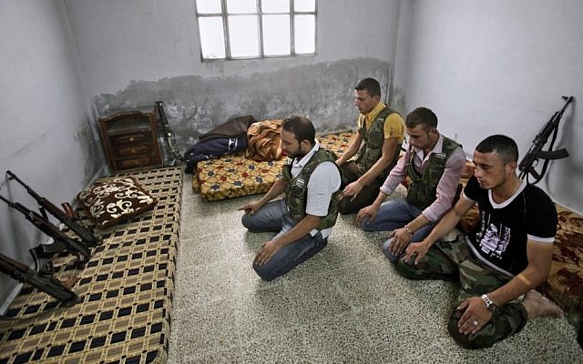 Syrian rebels pray at their headquarters near Aleppo, September 10 (photo credit: AP/Muhammed Muheisen) Syrian rebels pray at their headquarters near Aleppo, September 10 (photo credit: AP/Muhammed Muheisen)