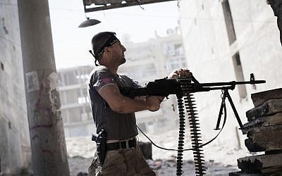 A Free Syrian Army fighter fires at Syrian Army positions (photo credit: AP/Manu Brabo)