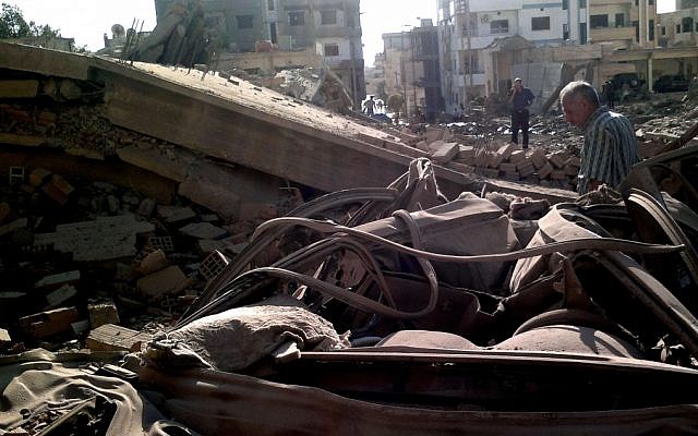 Syrian men inspect the scene of a car bomb attack in Qamishli, 497 miles (800 kilometers) northeast Damascus, Syria, Sunday, Sept. 30 (photo credit: AP/SANA) Syrian men inspect the scene of a car bomb attack in Qamishli, 497 miles (800 kilometers) northeast Damascus, Syria, Sunday, Sept. 30 (photo credit: AP/SANA)