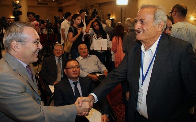 Syrian opposition members shake hands in a rare meeting in Damascus, September 23 (photo credit: AP/Bassem Tellawi)