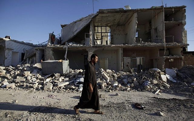 A Syrian man walks by a house destroyed in a Syrian government bombing in Azaz, near Aleppo, August 24, 2012 (photo credit: AP/Muhammed Muheisen) A Syrian man walks by a house destroyed in a Syrian government bombing in Azaz, near Aleppo, August 24, 2012 (photo credit: AP/Muhammed Muheisen)