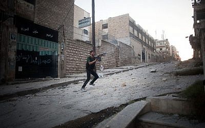 A opposition soldier fires towards Syrian Army positions in Aleppo, Syria, on Saturday September 8 2012 (photo credit: AP/Manu Brabo)