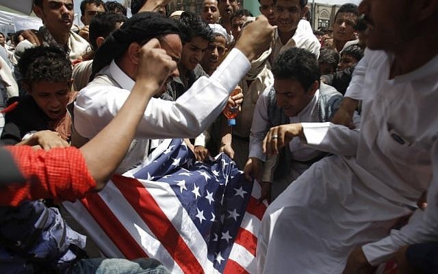Protesters destroy an American flag pulled down during clashes with police near the U.S. Embassy in Sanaa, Yemen, Friday, Sept. 14, 2012, as part of widespread anger across the Muslim world about a film ridiculing Islam's Prophet Muhammad. (AP Photo/Hani Mohammed)