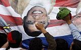 Pakistani protesters hold a banner depicting US President Barack Obama and pastor Terry Jones during a rally in Peshawar  (photo credit: AP/Mohammad Sajjad)