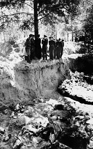 In this May 1943 file photo, a group of American and British POWs being held by the Germans, including Lt. Col. John H. Van Vliet Jr. and Capt. Donald B. Stewart, look over a mass grave where murdered Polish officers are buried, near Smolensk, Russia. Newly declassified documents being opened to the public on Monday, Sept. 10, 2012, by the US National Archives show that Van Vliet and Stewart sent coded messages to Washington after their visit saying they believed the German account of Soviet guilt. (photo credit: AP Photo/File)