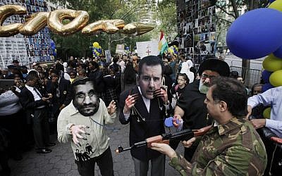 Men wearing masks of Iranian President Mahmoud Ahmadinejad, left, Syrian President Bashar Assad, center, and Iranian Ayatollah Ali Khamenei are joined by a man in military garb carrying a toy gun during a protest led by Iranian Americans and Syrian Americans outside the United Nations on September 26 in New York. (photo credit: AP/Mark Lennihan)