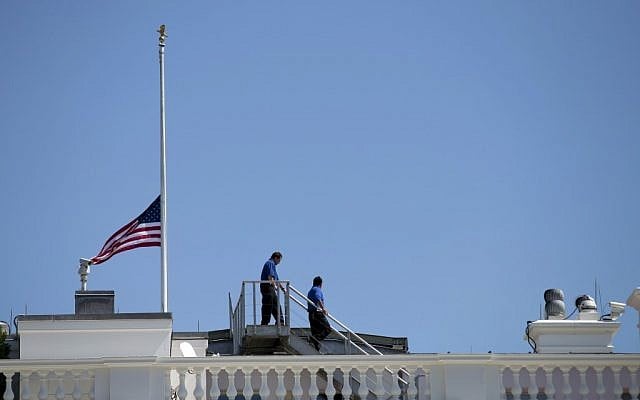 White House workers walk on the roof of the White House after lowering the flag to half staff for the death of US ambassador to Libya Christopher Stevens, Wednesday, Sept. 12, 2012 in Washington. (photo credit: AP/Evan Vucci)