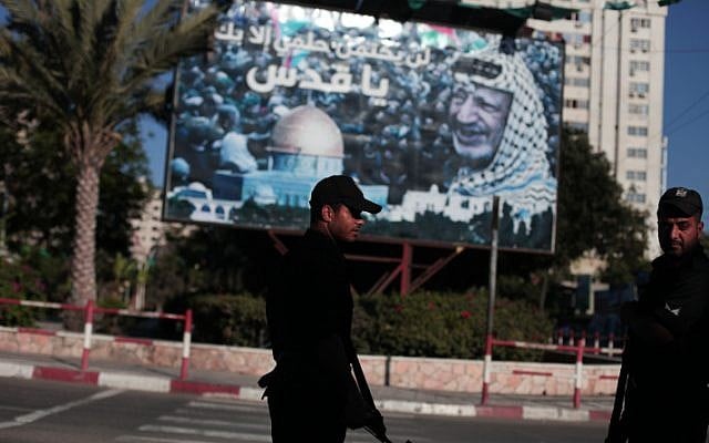 A Hamas police officer stands in front of graffiti showing late Palestinian leader Yasser Arafat in Gaza City in July. (photo credit: Wissam Nassar/Flash90) A Hamas police officer stands in front of graffiti showing late Palestinian leader Yasser Arafat in Gaza City in July. (photo credit: Wissam Nassar/Flash90)
