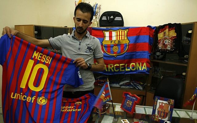A Palestinian vendor stands among flags and shirts of Barcelona's football team at a sporting goods store in Rafah, in the southern Gaza strip, on September 29 (photo credit: Abed Rahim Khatib/Flash90) A Palestinian vendor stands among flags and shirts of Barcelona's football team at a sporting goods store in Rafah, in the southern Gaza strip, on September 29 (photo credit: Abed Rahim Khatib/Flash90)