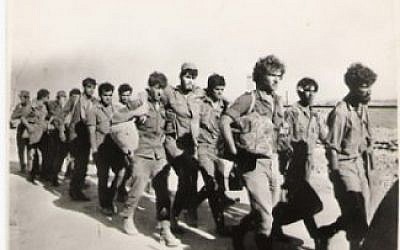 Uri Ehrenfeld supporting another soldier as they are marched to captivity. (Photo credit: Courtesy: Erim Balaila)