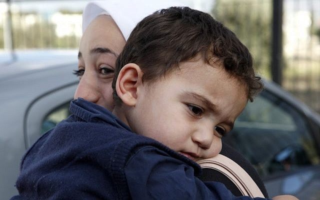 Bushr al-Tawashi, as he is carried by his mother Arin Al Dakkar, outside of a private Sigma TV station, in Nicosia, Cyprus, Friday. (photo credit: AP)