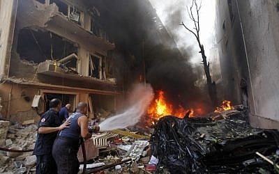 Lebanese firefighters extinguish burning cars at the scene of an explosion in the mostly Christian neighborhood of Achrafiyeh, Beirut, Lebanon, Friday Oct. 19 (photo credit: AP/Hussein Malla)