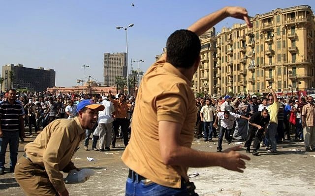 A protester throws a stone after scuffles broke out Friday between groups of several hundred protesters in Cairo's Tahrir square when chants against the new Islamist president angered some in the crowd. (photo credit: AP Photo/Khalil Hamra) A protester throws a stone after scuffles broke out Friday between groups of several hundred protesters in Cairo's Tahrir square when chants against the new Islamist president angered some in the crowd. (photo credit: AP Photo/Khalil Hamra)