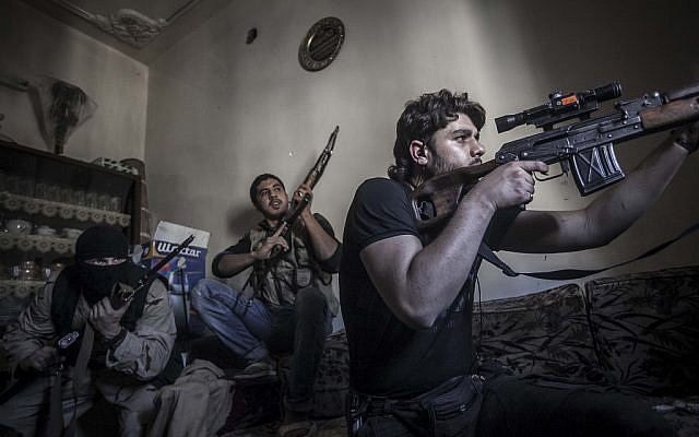 Illustrative: In this Monday, Oct. 29, 2012 photo, a rebel sniper aims at Syrian army positions in the Aleppo Jedida district, Syria (photo credit: Narciso Contreras/AP) Illustrative: In this Monday, Oct. 29, 2012 photo, a rebel sniper aims at Syrian army positions in the Aleppo Jedida district, Syria (photo credit: Narciso Contreras/AP)