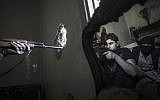 In this Monday, Oct. 29, 2012 photo, a rebel sniper aims at a Syrian army position, seen with another rebel fighter reflected in a mirror, in a residential building in the Jedida district of Aleppo, Syria (photo credit: AP Photo/Narciso Contreras)