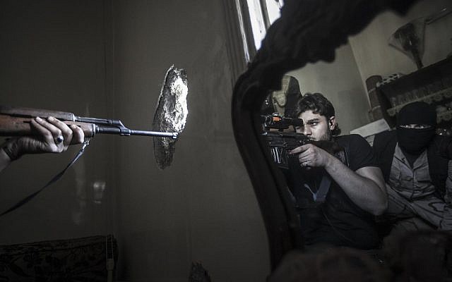 In this Monday, Oct. 29, 2012 photo, a rebel sniper aims at a Syrian army position, seen with another rebel fighter reflected in a mirror, in a residential building in the Jedida district of Aleppo, Syria (photo credit: AP Photo/Narciso Contreras) In this Monday, Oct. 29, 2012 photo, a rebel sniper aims at a Syrian army position, seen with another rebel fighter reflected in a mirror, in a residential building in the Jedida district of Aleppo, Syria (photo credit: AP Photo/Narciso Contreras)