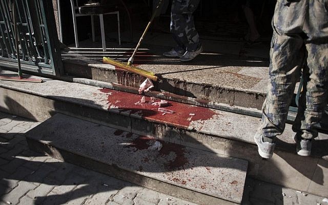 An employee cleans the floor outside the Dar El Shifa hospital in Aleppo, Syria on Thursday (photo credit: AP/Manu Brabo)