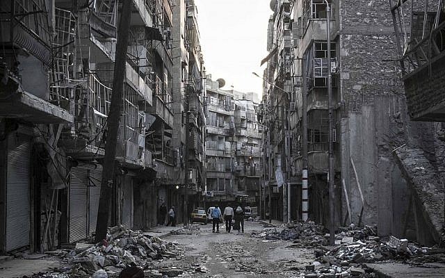 Syrians walk among the debris of buildings damaged by heavy shelling southeast of Aleppo on Saturday (photo credit: AP/Narciso Contreras) Syrians walk among the debris of buildings damaged by heavy shelling southeast of Aleppo on Saturday (photo credit: AP/Narciso Contreras)