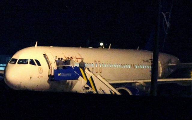 People gather atop the aircraft steps alongside a Syrian passenger plane that was forced by Turkish jets to land at Esenboga airport in Ankara, Turkey, October 10, 2012 (photo credit: AP/Burhan Ozbilici) People gather atop the aircraft steps alongside a Syrian passenger plane that was forced by Turkish jets to land at Esenboga airport in Ankara, Turkey, October 10, 2012 (photo credit: AP/Burhan Ozbilici)