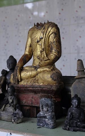 A Buddha statue stands amidst the ruins of a Buddhist temple that was torched Sunday by Muslims over an alleged derogatory photo of the Quran on Facebook. The temple is located in the coastal district of Cox's Bazar, Bangladesh. (photo credit: AP Photo)