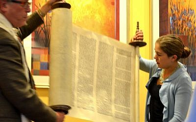 Charlotte Smith and Rabbi Jerry Levy dedicate the family Torah scroll rescued by her great-great-grandfather. (Julie Ann Kodmur via JTA)