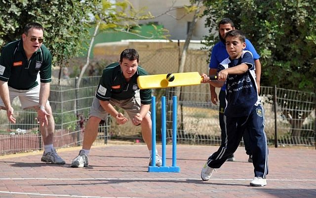 Nigel Adams, MP for Selby and Ainsty, left, and Guy Opperman, MP for Hexham, center, coaching a Bedouin cricketer in Hura (photo credit: David Katz/The Israel Project)