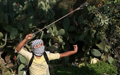 Illustrative photo of a  Palestinian youth hurling a stone in the West Bank city of Naalin in 2009 (photo credit: Miriam Alster/ flash90)