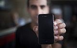 An illustrative photo of a man holding an iPhone (Yonatan Sindel/Flash90)