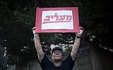 A Maariv newspaper worker protests outside the Prime Minister's Residence. The sign reads 'insulting' -- a play on words of the newspaper Maariv. (photo credit: Yonatan Sindel/Flash90)