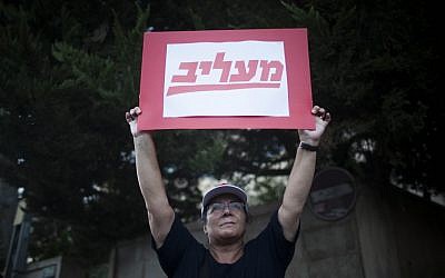 A Maariv newspaper worker protests outside the Prime Minister's Residence. The sign reads 'insulting' -- a play on words of the newspaper Maariv. (photo credit: Yonatan Sindel/Flash90)