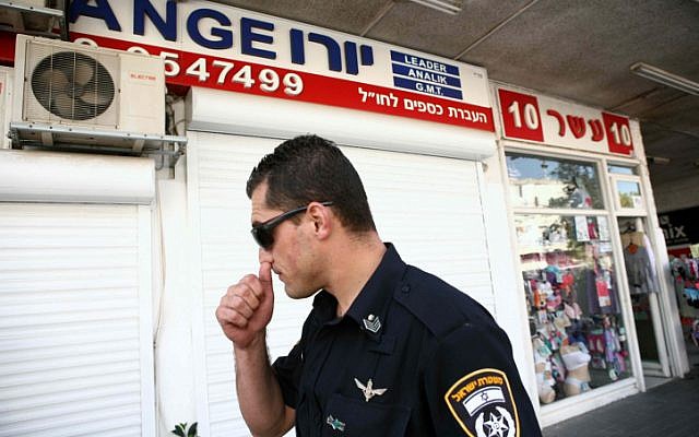 A police officer stands outside a money exchange kiosk in Herzliya whose operators were arrested under suspicion of money laundering on Wednesday, October 10, 2012 (Yehoshua Yosef/Flash90) A police officer stands outside a money exchange kiosk in Herzliya whose operators were arrested under suspicion of money laundering on Wednesday, October 10, 2012 (Yehoshua Yosef/Flash90)
