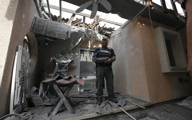 A policeman examines the damage dealt to a house by a rocket fired from the Gaza Strip on Wednesday, October 24. (photo credit: Tsafrir Abayov/Flash90) A policeman examines the damage dealt to a house by a rocket fired from the Gaza Strip on Wednesday, October 24. (photo credit: Tsafrir Abayov/Flash90)