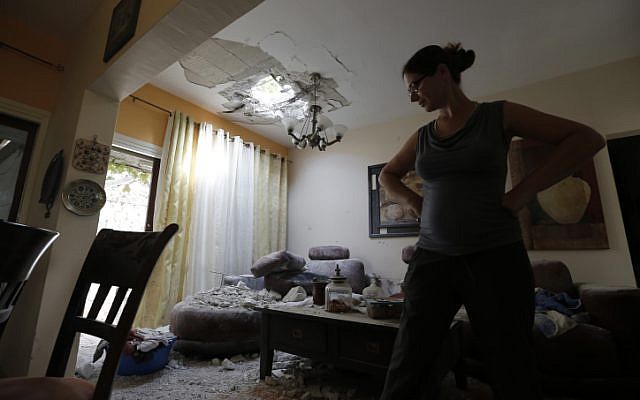 A woman examines a house in southern Israel damaged by a rocket fired by Palestinians in the Gaza Strip, Wednesday, October 24, 2012. (photo credit: Tsafrir Abayov/Flash90)