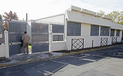 A man leaves the synagogue in Argenteuil, west of Paris, where services were canceled Saturday after attackers shot eight blank bullets at the building. (Remy de la Mauviniere/AP)