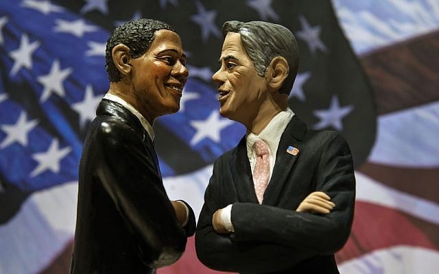 Two statuettes depicting President Barack Obama, left, and Republican rival Mitt Romney are backdropped by the Stars and Stripes in a shop which sells Christmas nativity figures in Naples, Italy, Monday, Oct. 22, 2012, hours ahead of their third and final presidential debate in Boca Raton, Florida. (photo credit: Salvatore Laporta/AP)