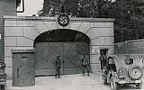 US troops guard the main entrance to the Dachau concentration camp, just after liberation in 1945 (photo credit: US National Archives/Wikimedia Commons)