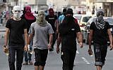 Illustrative photo of masked Bahraini anti-government protesters carrying Molotov cocktails ahead of a march in Manama in 2012. (photo credit: AP/Hasan Jamali)