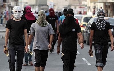Illustrative photo of masked Bahraini anti-government protesters carrying Molotov cocktails ahead of a march in Manama in 2012. (photo credit: AP/Hasan Jamali)