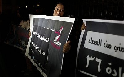 Egyptian female activists, one carrying a placard that reads in Arabic "the constitution is not about the majority, tomorrow you are the minority," during an anti Islamist dominated constitutional assembly protest in Cairo, Egypt, Tuesday, Oct. 2 (photo credit: AP/Nasser Nasser)