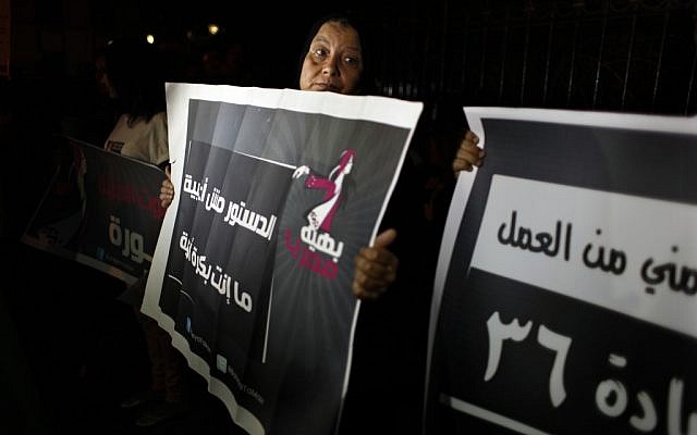 Egyptian female activists, one carrying a placard that reads in Arabic "the constitution is not about the majority, tomorrow you are the minority," during an anti Islamist dominated constitutional assembly protest in Cairo, Egypt, Tuesday, Oct. 2 (photo credit: AP/Nasser Nasser)