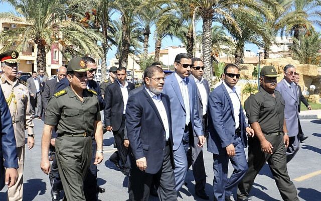 President Mohammed Morsi, center, walks with officials during a visit to el-Arish on Oct. 5. (photo credit: AP/Egyptian Presidency)