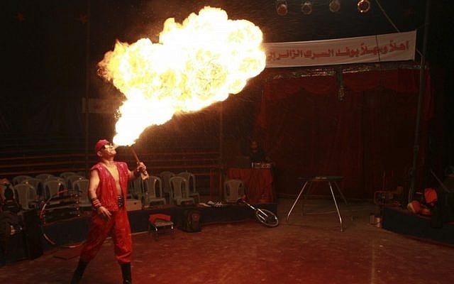 In this photo taken Thursday, Oct. 25, 2012, Rifat al-Gureisy, 55, a member of the Egyptian National Circus, blows fire during a practice in Gaza City. The circus came to Gaza on Friday, accompanied by blaring music, juggling clowns and fire blowers — but getting it there required its own high-wire act. No women performers were included for fear of offending conservative Palestinians and the Gaza Strip's militant Hamas rulers, and the circus' lone lion and tiger were left behind because of the high cost of transporting them legally into Gaza. (AP Photo/Adel Hana)