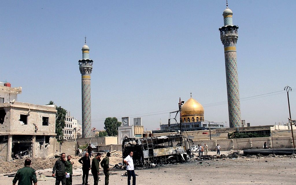 This June 14, 2012 photo shows Syrian security forces at the site where a car bomb exploded near the shrine of Sayyida Zeinab, visible in the background, in a suburb of Damascus, Syria (photo credit:AP Photo/Bassem Tellawi) This June 14, 2012 photo shows Syrian security forces at the site where a car bomb exploded near the shrine of Sayyida Zeinab, visible in the background, in a suburb of Damascus, Syria (photo credit:AP Photo/Bassem Tellawi)
